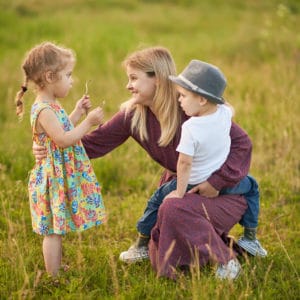 Happy family, son and girl i in wheat field at sunset. The concept of organic farming and healthy lifestyle, healthy food, happiness and joy. Cow in the background