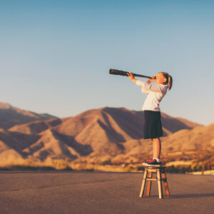 Young Business Girl Looks through Telescope
